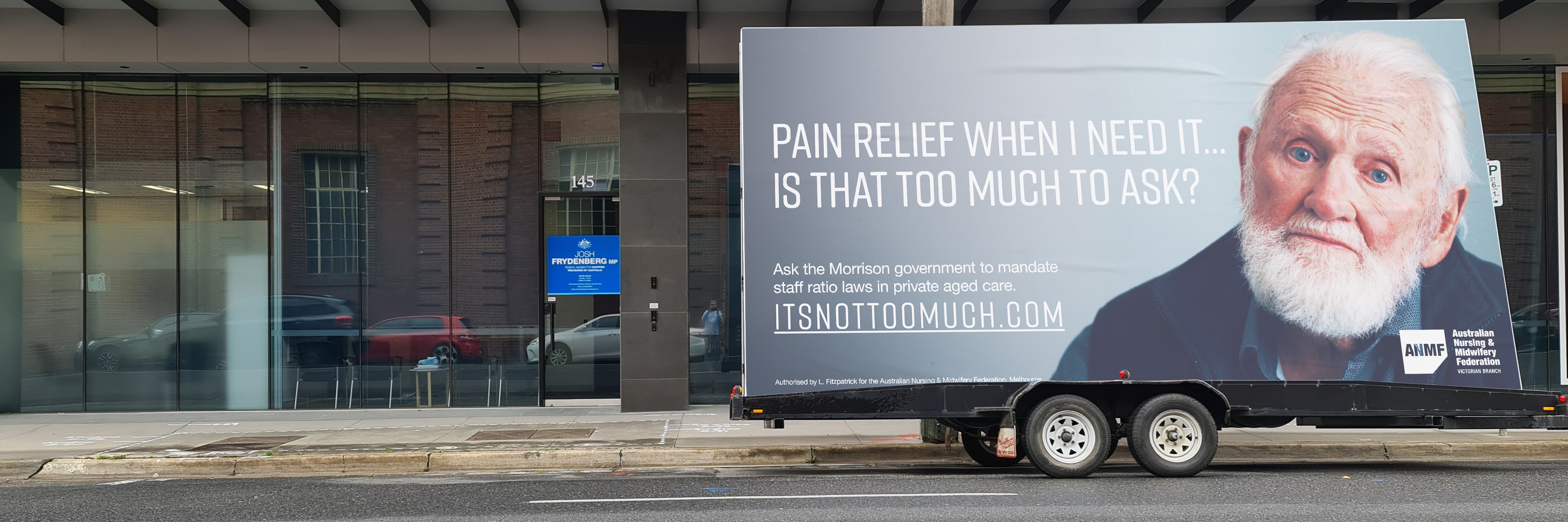 The ‘It’s not too much’ campaign billboard outside Federal Treasurer Josh Frydenberg’s Kooyong electorate office in Hawthorn East.